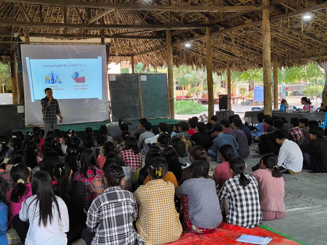 Students gathered for an eduLamp learning session under a bamboo shelter